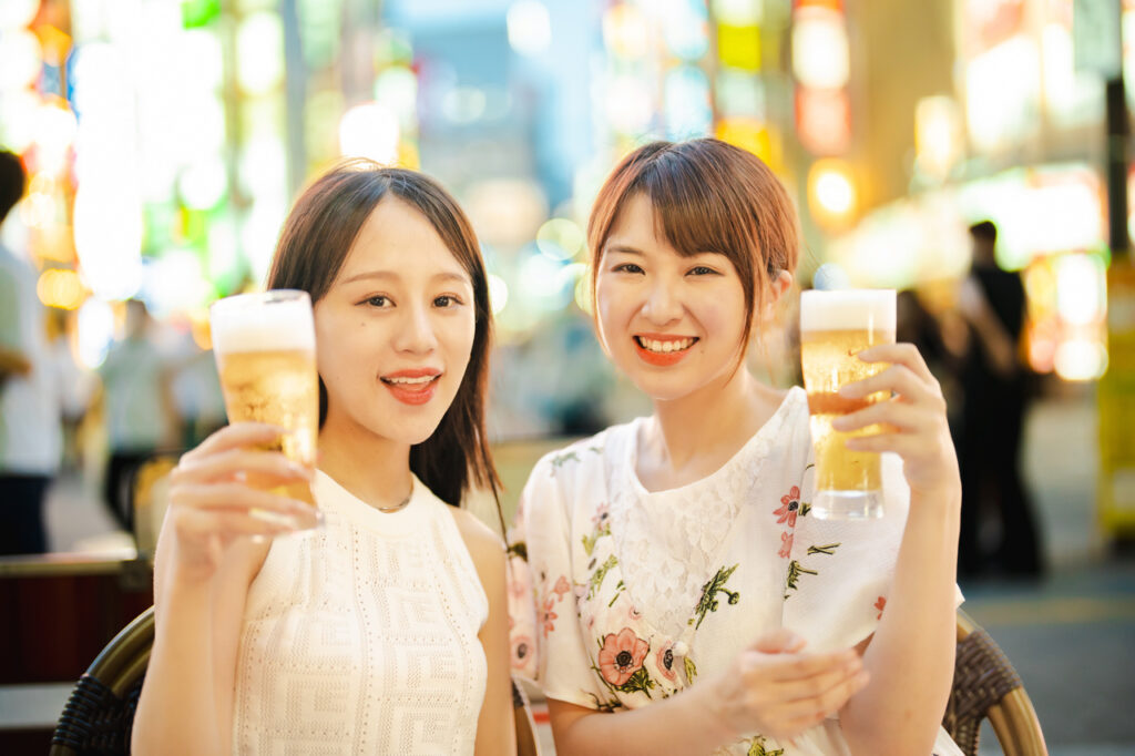 お酒を持ち楽しそうにしている２人の若い女性